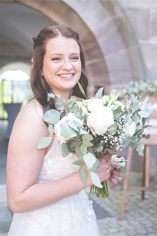 Hochzeitsfotos Bamberg Braut hält weissen Blumenstrauss