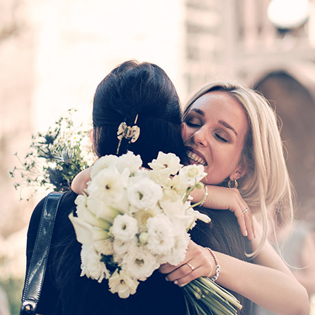Hochzeitsfotos Bamberg Braut mit Brautstrauss umarmt Freundin